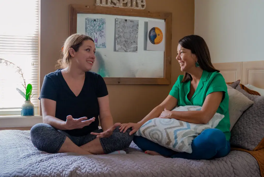 Women sharing feelings at rehab smiling